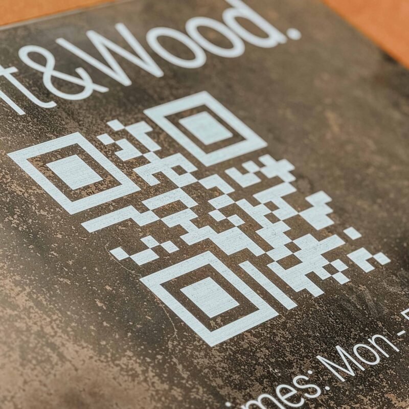 Solid steel company sign printed in white with logo, text, and integrated QR code.